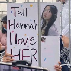 a woman holding a sign that says tell hannah i love her on the side of a bus