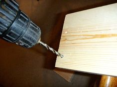 a drill is being used to attach wood planks on a table with a screwdriver