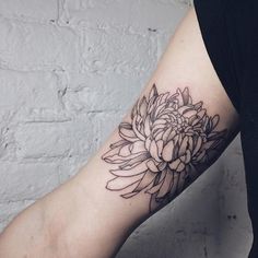 a woman's arm with a flower tattoo on it