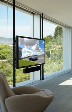 a large flat screen tv mounted to the side of a wall next to a window