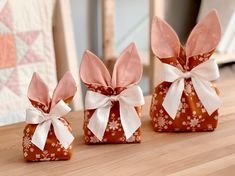 three small bags with bows on them sitting on a table