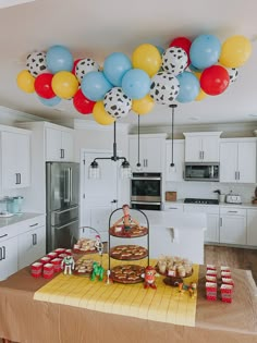 a kitchen with balloons and cake on the counter