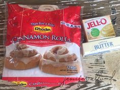 cinnamon rolls with cream cheese icing and butter on a wooden table next to other snacks