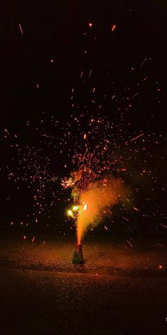 a fire hydrant is spewing out fireworks at night