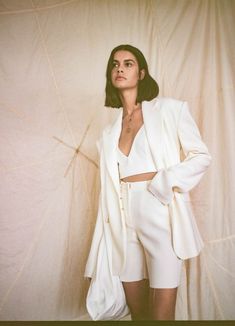 a woman standing in front of a white backdrop