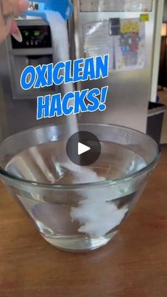 a glass bowl filled with liquid sitting on top of a wooden table