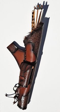 an arrow and bow holder made out of leather with arrows sticking out of the back