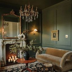 a living room filled with furniture and a chandelier above a fire place in front of a fireplace