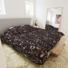 a bedroom with a bed, mirror and rugs on the floor in front of it