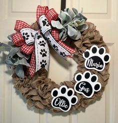 a dog's paw print wreath with personalized magnets on the front door