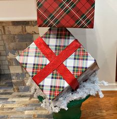 three wrapped presents are stacked on top of each other in a green pot with christmas decorations