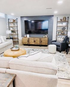 a living room filled with furniture and a flat screen tv mounted to the side of a wall