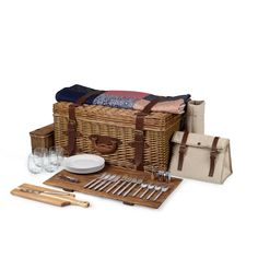 a picnic basket with utensils, wine glasses and napkins in front of it