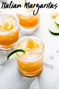 two glasses filled with orange margaritas and garnished with lime slices on the rim