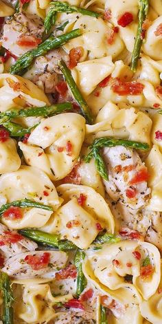 a pasta dish with asparagus, chicken and tomatoes