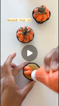 someone is decorating cupcakes with orange icing