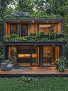 a small house with lots of plants on the roof and windows in the middle of it