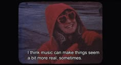 a woman wearing sunglasses and a red hoodie with the caption i think music can make things seem at bit more real sometimes