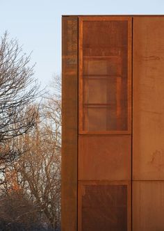 a tall metal building sitting next to a tree