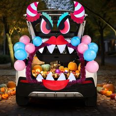 the trunk of a car decorated with balloons and other decorations, including an animal head