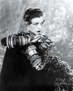 a woman holding a camera in her right hand and looking at the camera with both hands