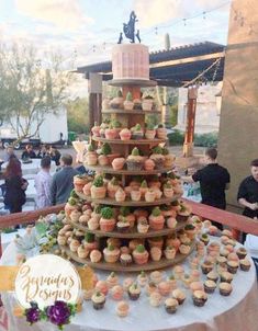 cupcakes are stacked on top of each other in front of a large cake