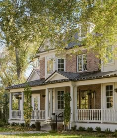 a large white house with lots of windows and porches on the front of it