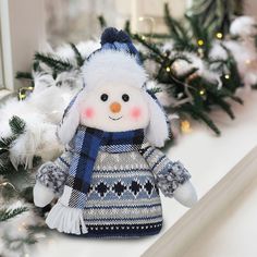 a snowman doll sitting on top of a mantle