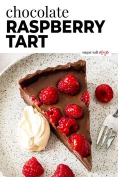 chocolate raspberry tart on a plate with whipped cream and fresh raspberries