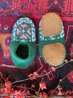 a pair of slippers sitting on top of a rug next to flowers and branches