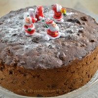 a chocolate cake with frosting and decorations on top is sitting on a glass plate