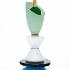 three different colored vases sitting on top of each other in front of a white background