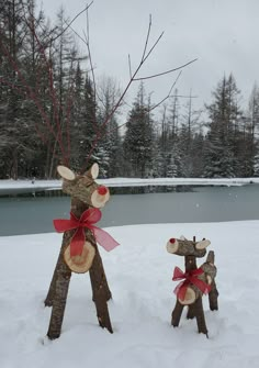 two wooden deer sculptures sitting in the snow