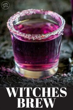 a glass filled with purple liquid sitting on top of a table