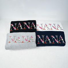 three pairs of name socks with flowers on them sitting on top of a white surface