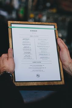 a person holding up a menu in their hands