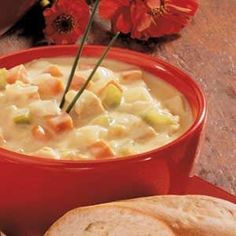 a red bowl filled with soup next to bread