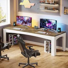 a desk with two computer monitors and a chair in front of it on a hard wood floor