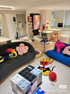 a living room filled with lots of furniture and toys on the floor next to each other