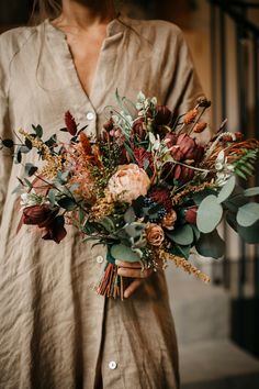 a woman holding a bouquet of flowers in her hands