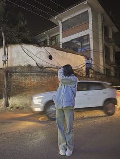 a person standing in front of a white car