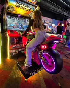 a woman riding on the back of a motorcycle in front of a slot machine at a casino