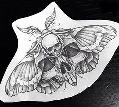 a sticker with a skull and butterfly on it's back side, sitting on a table