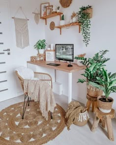 a home office with plants and wicker baskets on the wall, along with a computer