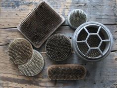 four different types of hair brushes sitting on top of a wooden table