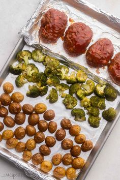 broccoli, tomatoes and other vegetables are on a baking sheet covered in tin foil