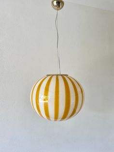 a yellow and white striped light hanging from a ceiling