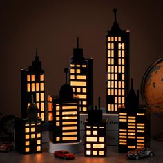 a group of lit up buildings sitting on top of a table next to a globe