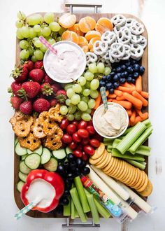 a platter filled with fruits, vegetables and dip