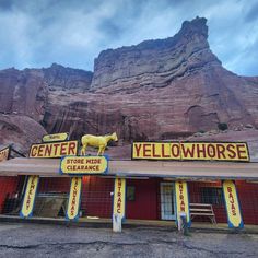 a yellow horse sign on the side of a building in front of a large mountain